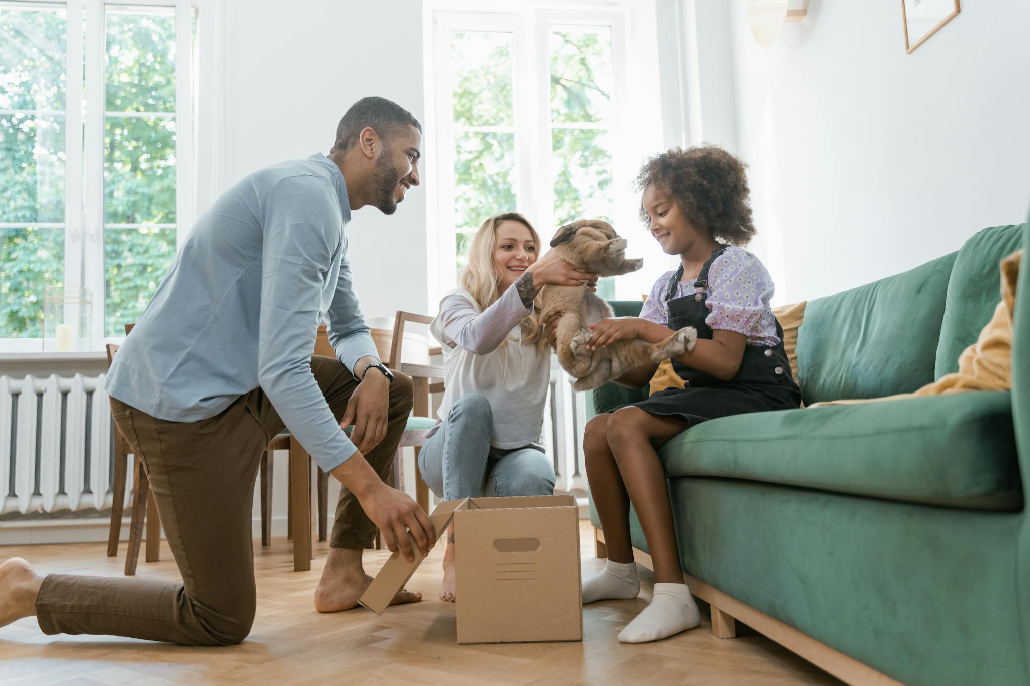 Diverse family welcoming a new pet dog in a cozy living room setting, surrounded by joy and smiles.